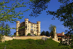 Sommeraufnahme vom Schloss Hohenschwangau mit blauer Himmel im Hintergrund 