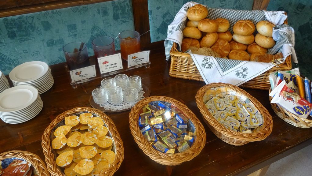 Breakfast buffet with bread, rolls and various spreads.