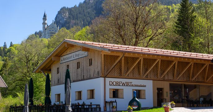 Picture of the Rest. Dorfwirt building with terrace and Neuschwanstein Castle in the background